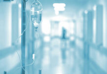 Why Cancer Treatments Stop Working For So Many Patients IV drip in a hospital corridor with a blurred background