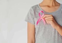Breast Cancer Risk: Family Genes Rewrite The Rules Person holding a pink ribbon on a gray shirt