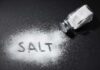 Sneaky Salt Habit, Big Liver Trouble Salt shaker spilling salt on a dark surface