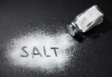 Sneaky Salt Habit, Big Liver Trouble Salt shaker spilling salt on a dark surface