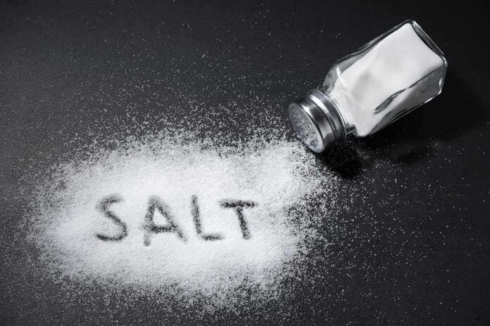 shutterstock_1039576777 Salt shaker spilling salt on a dark surface