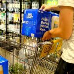 Processed Aisle: The Real Health Trap Shopper loading cases of beer into a grocery cart