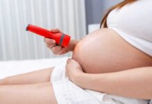 Invisible Toxins That Shape Pregnancy Outcomes Pregnant woman shining flashlight on bare belly