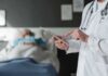 Shocking Gap: Cancer Patients Denied Relief Doctor using tablet beside hospital patient