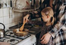 CDC Warning: Kitchen Habits That Cause Foodborne Illnesses Child cooking with adult at a stove