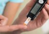 Late Night Habits Tied To DIABETES person using a blood glucose meter with a test strip