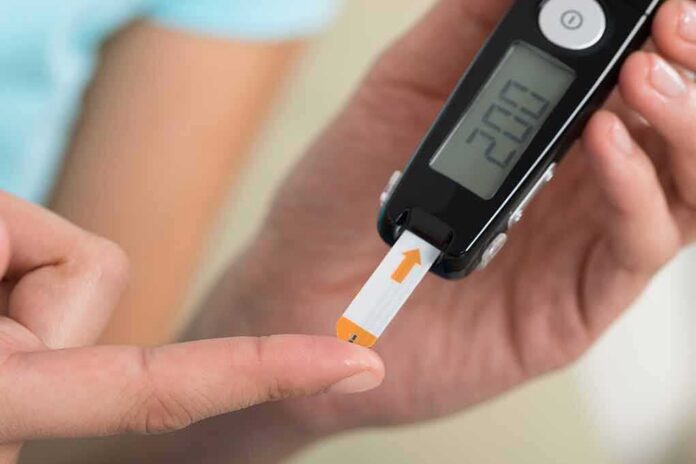 1783887984380-gi9wcc-shutterstock-366405458 person using a blood glucose meter with a test strip