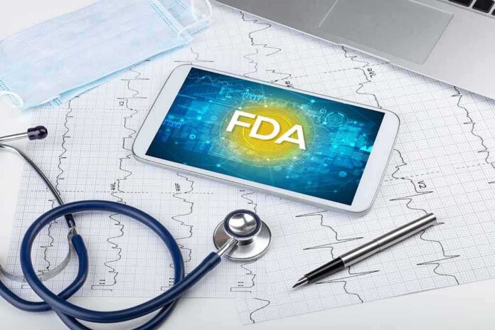 Tablet with FDA on screen amid medical tools and ECG charts