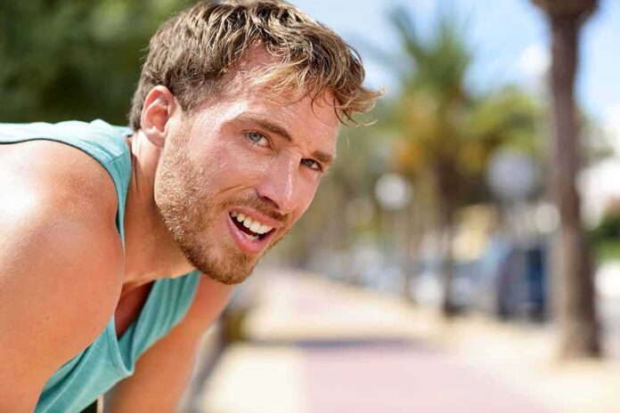 shutterstock_1017406066 man in athletic tank top resting outdoors