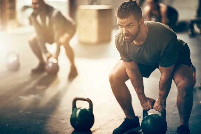 Man lifting a kettlebell in a gym