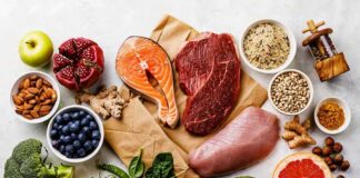 Assorted healthy foods with salmon, beef, chicken, fruits, vegetables, nuts, and grains