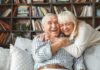 Senior couple hugging and laughing on a couch