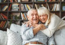 Senior couple hugging and laughing on a couch