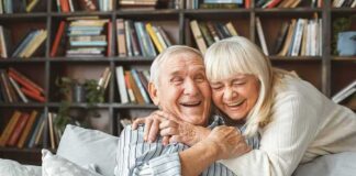 Senior couple hugging and laughing on a couch
