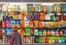 Child looking at a shop window filled with snacks and cereals
