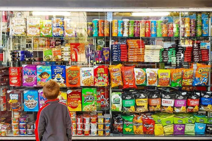 shutterstock_1100362217 Child looking at a shop window filled with snacks and cereals