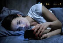 Comparison Trap: Engineered and Addictive Woman lying in bed looking at a smartphone