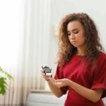 Woman using a blood glucose meter at home