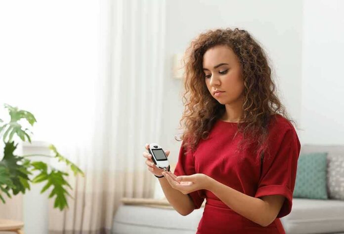 shutterstock_1341884993 Woman using a blood glucose meter at home