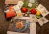 Meal kit ingredients with salmon, couscous, and vegetables on a counter