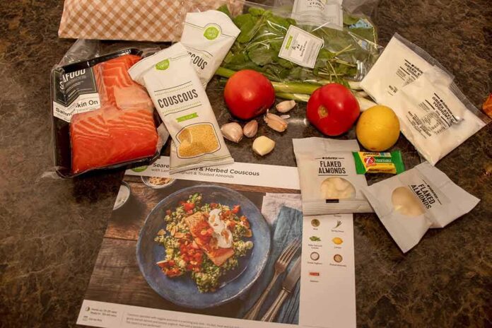 shutterstock_1806741964 Meal kit ingredients with salmon, couscous, and vegetables on a counter