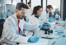 Big Money Circles Australia’s Cancer Breakthrough Scientist using a microscope in a modern laboratory