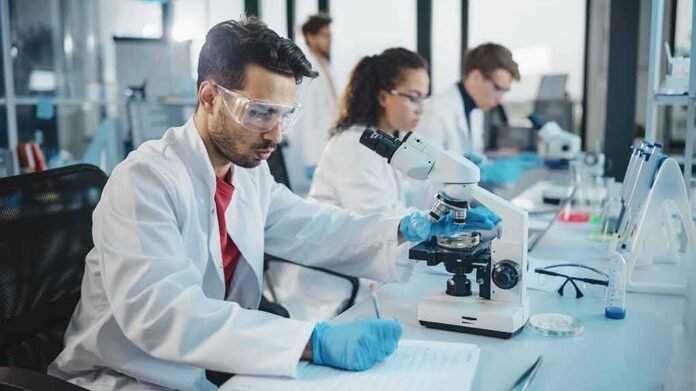 shutterstock_1922200196 Scientist using a microscope in a modern laboratory