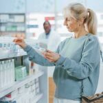 Woman shopping for medicine in a pharmacy aisle