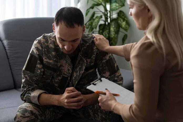 shutterstock_2110380992 Soldier in camouflage receives support from a counselor