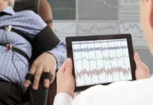 Neurostimulation for Chronic Pain Management Technician reviews polygraph readings on a tablet beside a seated subject