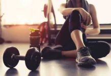 The Best 4 Dumbbell Exercises for Beginners person resting on gym floor with dumbbell and water bottle
