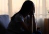 Emotional Suppression – The Silent Health Risk A silhouette of a person sitting with their head in their hands, conveying distress