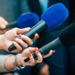 Cancer Flagged Additive Hides In Bread Reporters holding colorful microphones