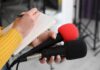 Colon Cancer Screening: The Age Conversation Journalist holding two microphones while writing in a notebook