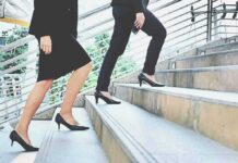 Two businesspeople in formal wear walking up stairs
