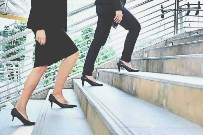 Two businesspeople in formal wear walking up stairs