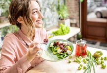 Woman eating a fresh salad at a bright cafe