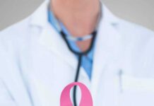 How “Cured” Cancer Can Come Back Doctor holding stethoscope with pink ribbon in front