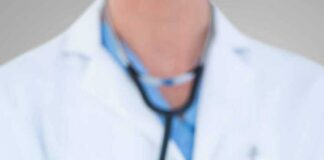 Doctor holding stethoscope with pink ribbon in front