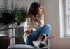 Woman sitting curled up on a chair looking out a window