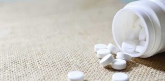 White tablets spilling from a plastic bottle