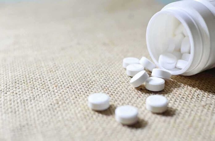 shutterstock_1138934090-1 White tablets spilling from a plastic bottle