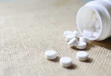 White tablets spilling from a plastic bottle