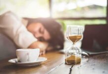 Nap Timing Beats Duration Hourglass on table with coffee cup and sleeping person in background