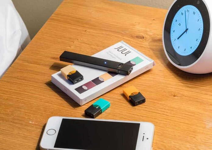 shutterstock_1164563215 vape pen and pods on a wooden nightstand