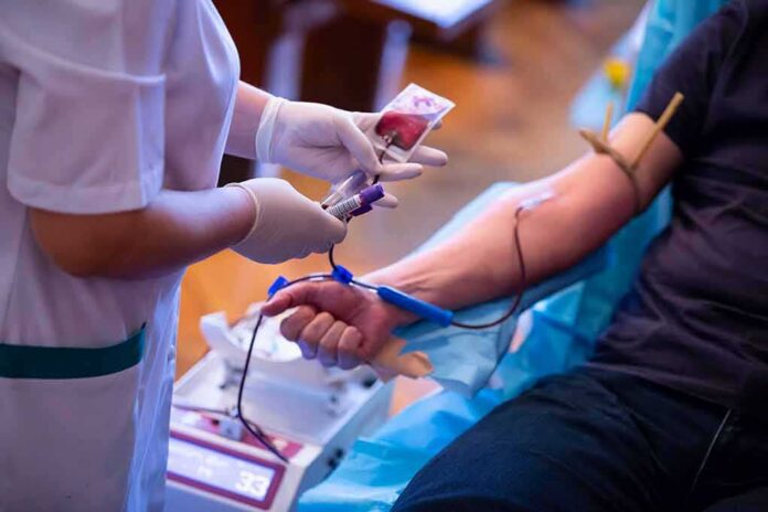 Nurse draws blood from a donor's arm