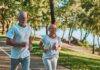 Two adults jogging on a tree-lined lakeside path