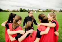 Stunning Stat Exposes Youth Sports Gatekeeping Coach talks to youth team in a huddle on a field