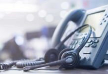 Outdated 911 Gear Endangering Millions? Headset resting on an office desk phone