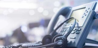 Headset resting on an office desk phone